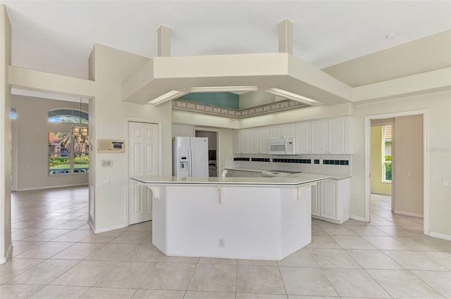 kitchen featuring a large island, white cabinets, and white appliances