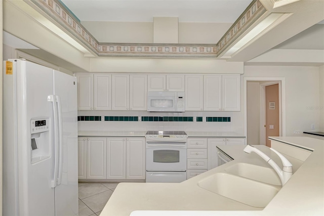 kitchen featuring light tile patterned floors, decorative backsplash, sink, white cabinets, and white appliances