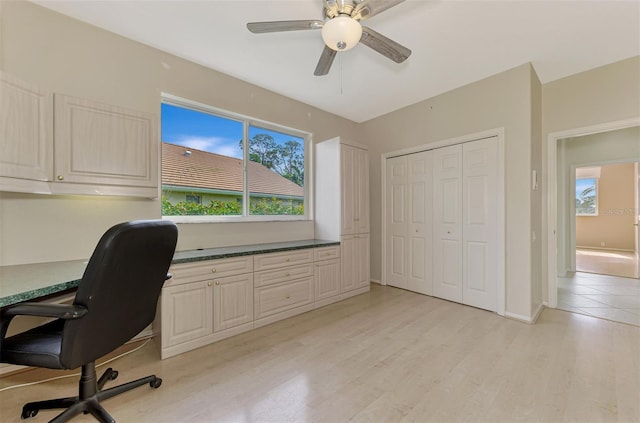 home office with light hardwood / wood-style floors, ceiling fan, and built in desk