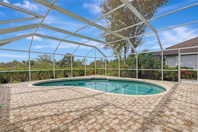 view of pool featuring glass enclosure and a patio