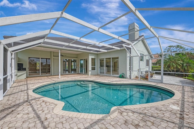 view of swimming pool featuring a lanai, ceiling fan, and a patio