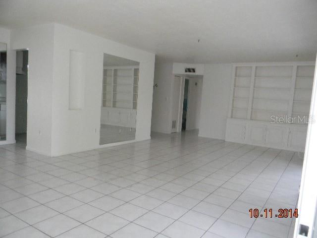 empty room featuring built in features and light tile patterned flooring