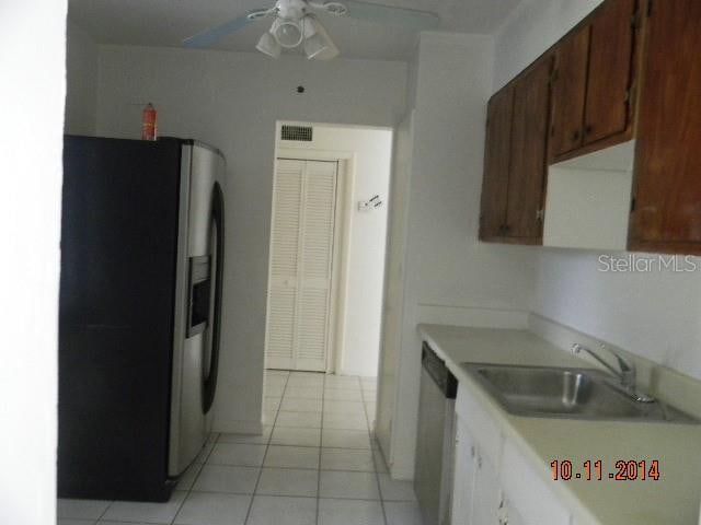 kitchen with sink, light tile patterned floors, ceiling fan, and stainless steel appliances