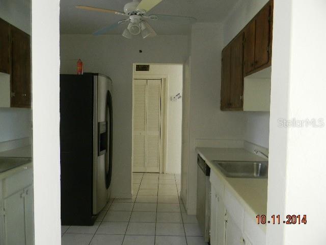 kitchen featuring white cabinetry, sink, appliances with stainless steel finishes, ceiling fan, and light tile patterned floors