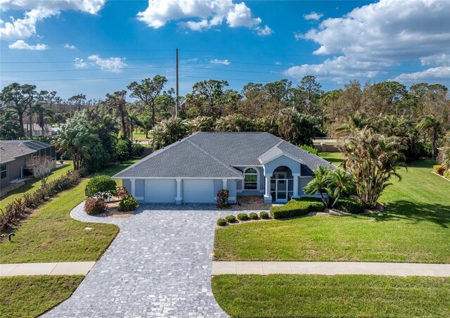 110 Abercrombie Ave, Englewood, FL 34223 - ranch-style home featuring a garage, decorative driveway, a front yard, and view of wooded area