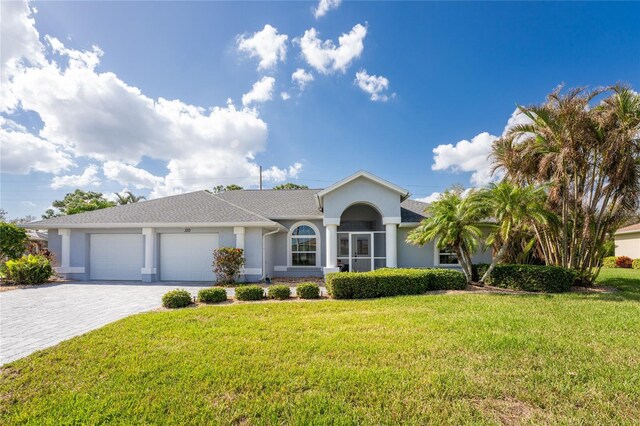 110 Abercrombie Ave, Englewood, FL 34223 - single story home with stucco siding, an attached garage, decorative driveway, and a front yard