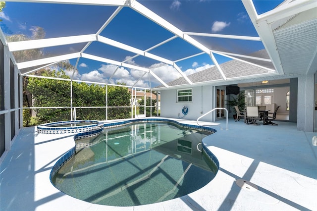 view of pool with a patio, an in ground hot tub, and glass enclosure