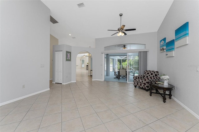 living room with ceiling fan, light tile patterned flooring, and lofted ceiling