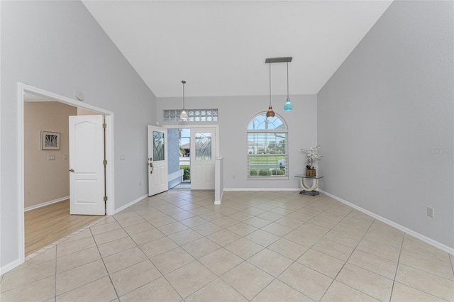 interior space with high vaulted ceiling and light tile patterned floors