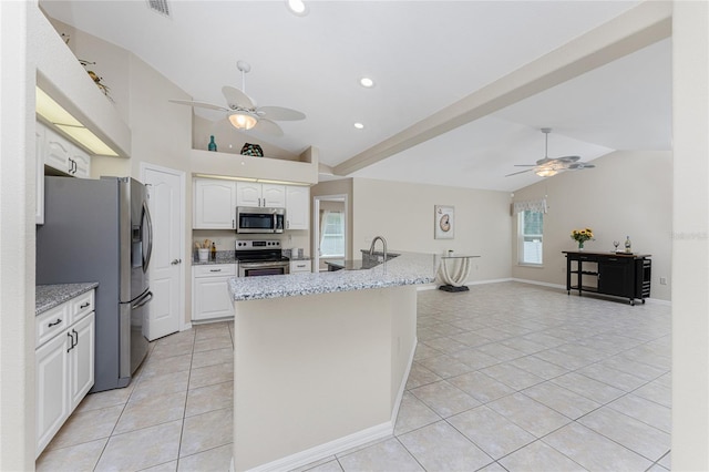 kitchen with appliances with stainless steel finishes, white cabinets, and vaulted ceiling