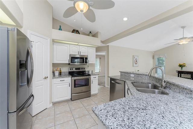 kitchen with appliances with stainless steel finishes, lofted ceiling, white cabinetry, and sink