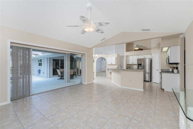 unfurnished living room with sink, ceiling fan, light tile patterned flooring, and lofted ceiling