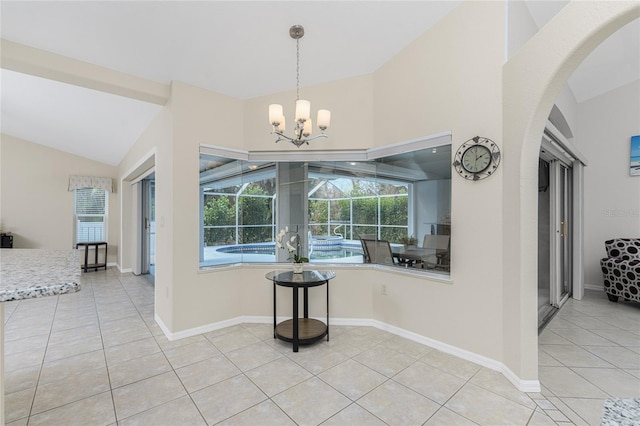 tiled dining room featuring vaulted ceiling and a chandelier