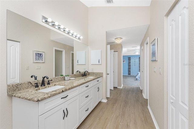 110 Abercrombie Ave, Englewood, FL 34223 - bathroom with double vanity, wood finished floors, baseboards, and ceiling fan