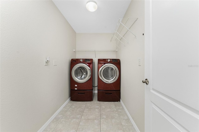 clothes washing area with washing machine and dryer and light tile patterned floors