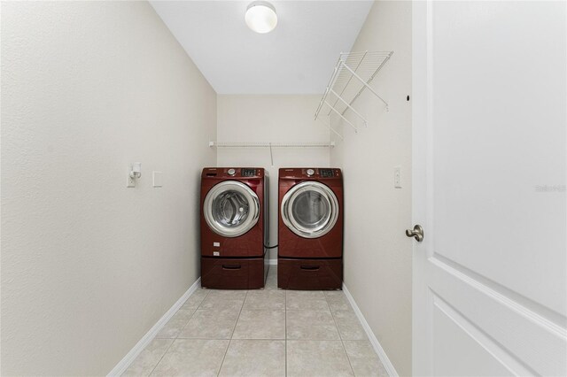 110 Abercrombie Ave, Englewood, FL 34223 - laundry area with washer and clothes dryer, light tile patterned floors, and baseboards