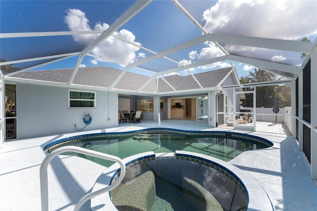 view of swimming pool with an in ground hot tub, a patio area, and glass enclosure