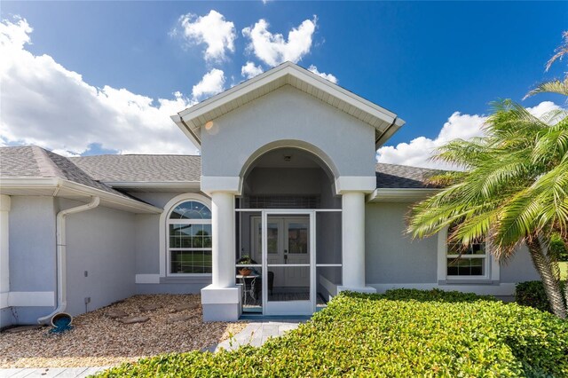 110 Abercrombie Ave, Englewood, FL 34223 - property entrance with french doors, roof with shingles, and stucco siding