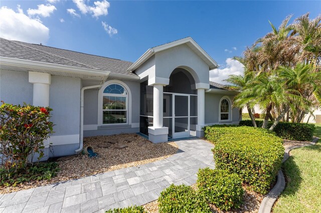 110 Abercrombie Ave, Englewood, FL 34223 - property entrance with roof with shingles and stucco siding