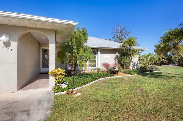 view of exterior entry featuring a yard