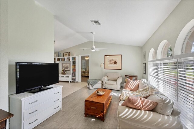 living room featuring light hardwood / wood-style floors, vaulted ceiling, and ceiling fan