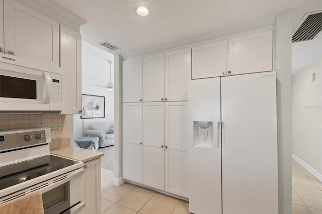 kitchen with white cabinetry, backsplash, white appliances, and light tile patterned flooring