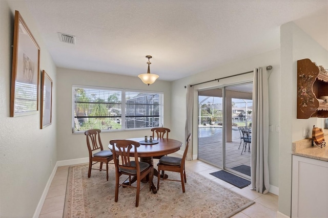 tiled dining area with a textured ceiling