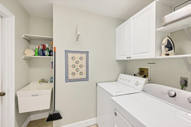 washroom with sink, cabinets, washing machine and dryer, and light tile patterned floors