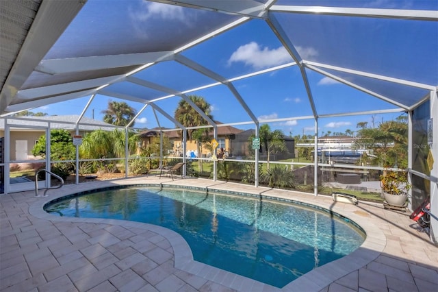 view of pool with glass enclosure and a patio