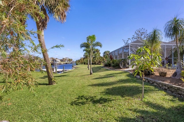 view of yard featuring a water view and glass enclosure