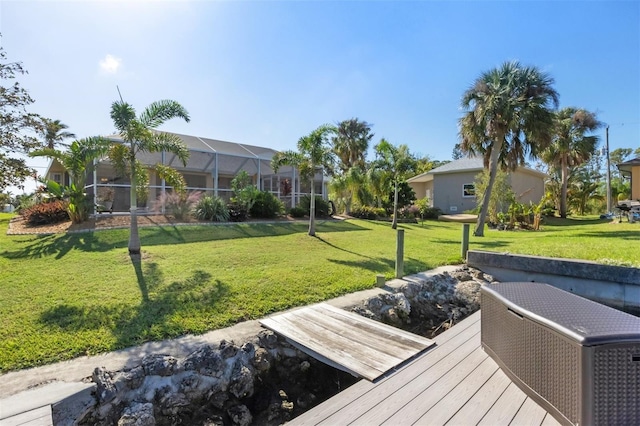 view of dock featuring a lawn and a lanai