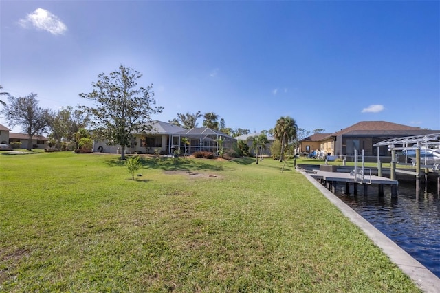 view of yard with glass enclosure, a boat dock, and a water view