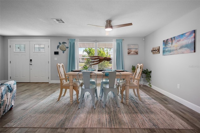 dining room featuring ceiling fan, a textured ceiling, and dark hardwood / wood-style flooring