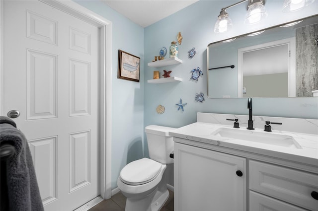 bathroom with toilet, vanity, and tile patterned flooring