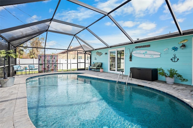 view of pool featuring a patio, glass enclosure, and a storage shed