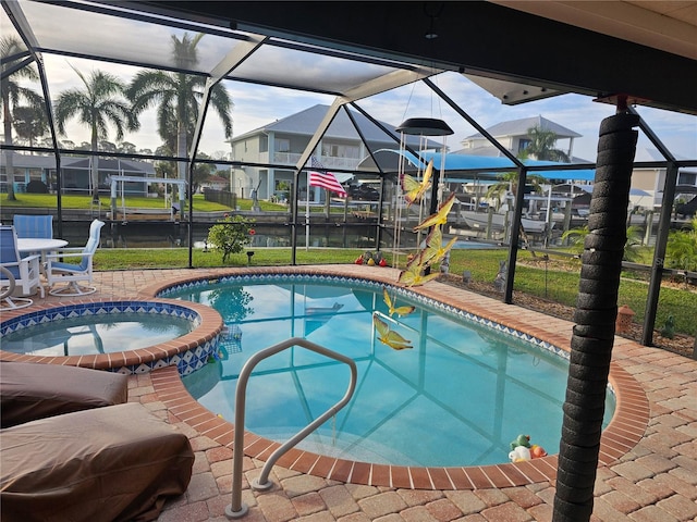 view of swimming pool with a patio, a lawn, a lanai, and an in ground hot tub