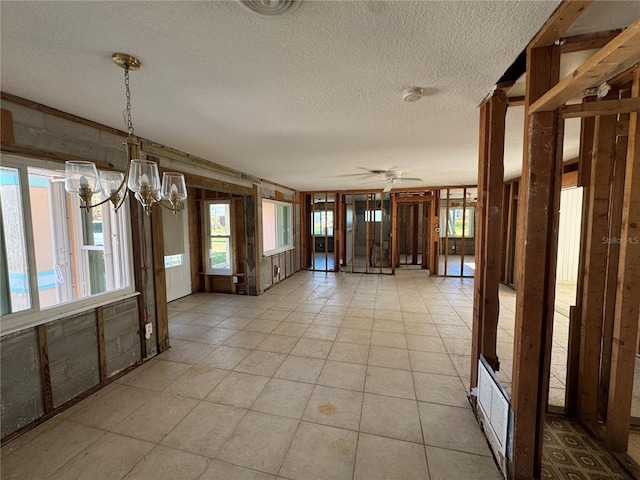 interior space with ceiling fan with notable chandelier