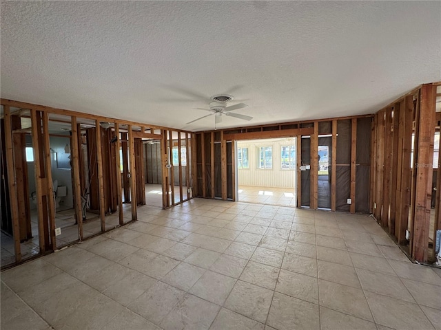 empty room featuring a textured ceiling and ceiling fan