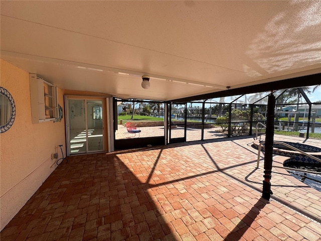 view of patio / terrace with a lanai and a water view