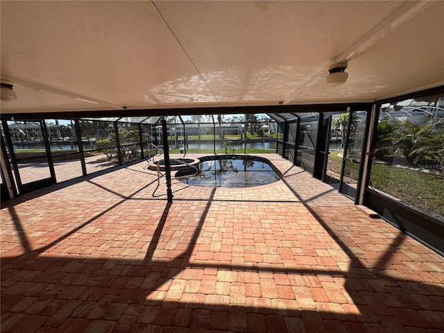 unfurnished sunroom featuring a hot tub and a water view