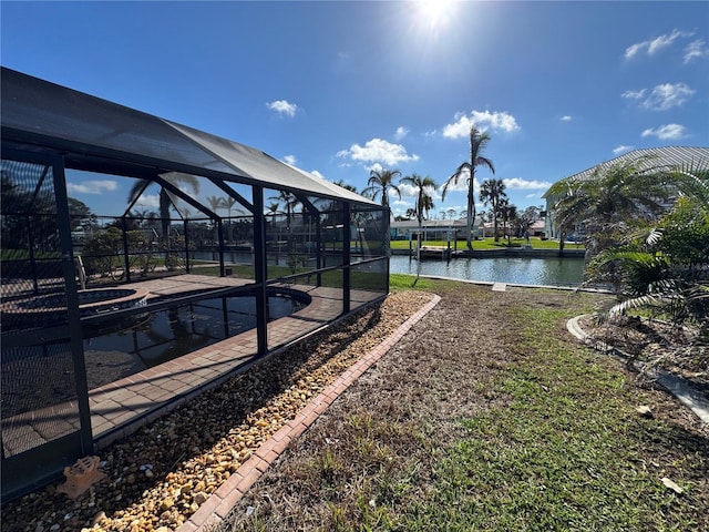 view of yard featuring glass enclosure and a water view