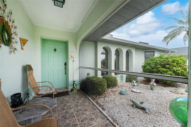 view of exterior entry with a patio