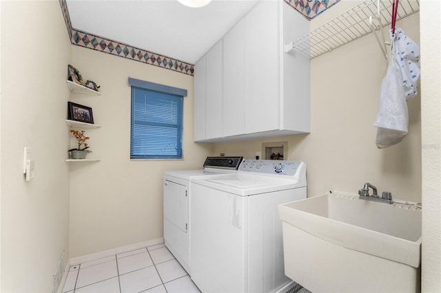 laundry area featuring washer and clothes dryer, a textured ceiling, light tile patterned floors, cabinets, and sink