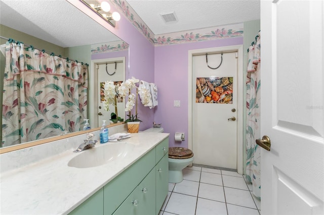 bathroom featuring vanity, a textured ceiling, tile patterned floors, and toilet