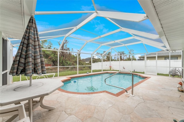 view of swimming pool featuring glass enclosure and a patio area