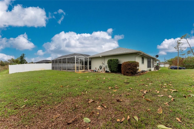 back of house with a yard and a lanai