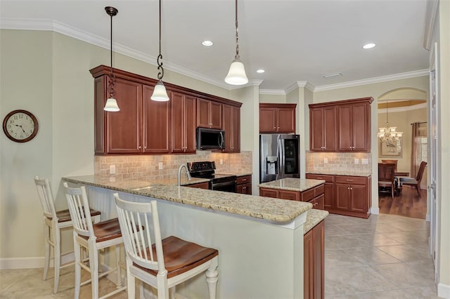 kitchen featuring pendant lighting, appliances with stainless steel finishes, light stone counters, decorative backsplash, and kitchen peninsula