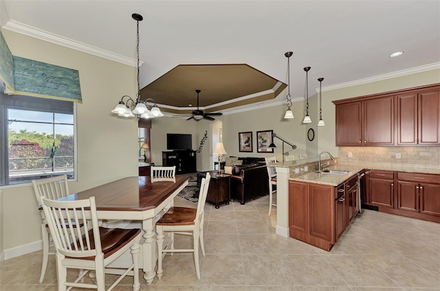 kitchen with crown molding, sink, hanging light fixtures, and kitchen peninsula