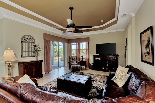 living room featuring crown molding, light tile patterned flooring, ceiling fan, and a tray ceiling