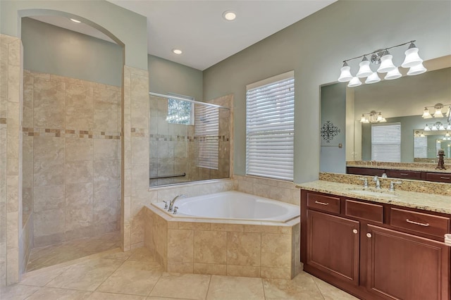 bathroom with tile patterned flooring, vanity, and plus walk in shower